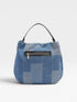 Blue patchwork handbag with a black zipper on a light gray background