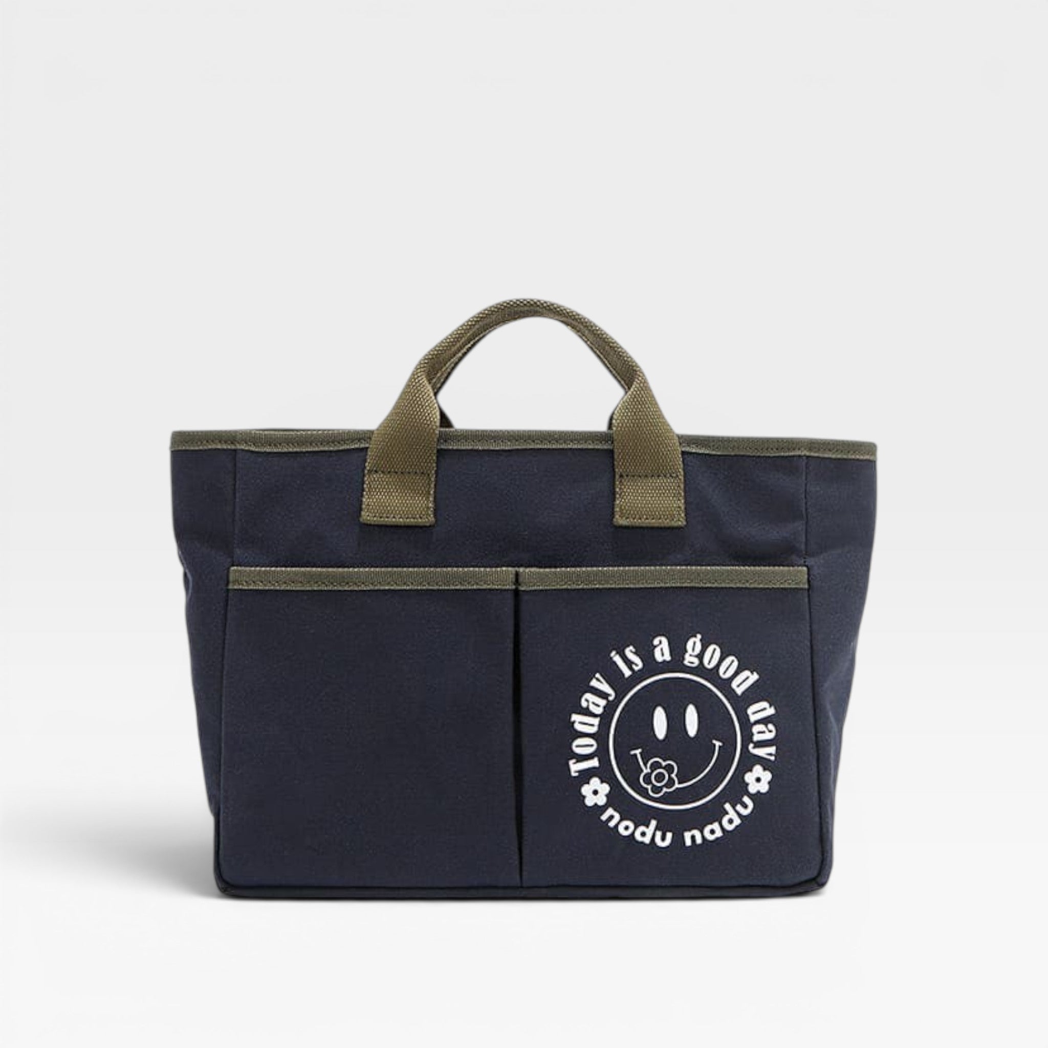 Navy tote bag with green handles and a smiley face design on a white background