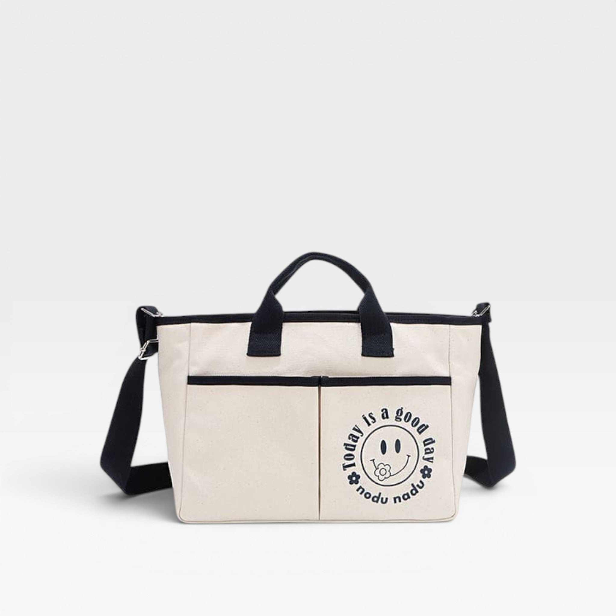 Beige tote bag with black handles and strap on a white background