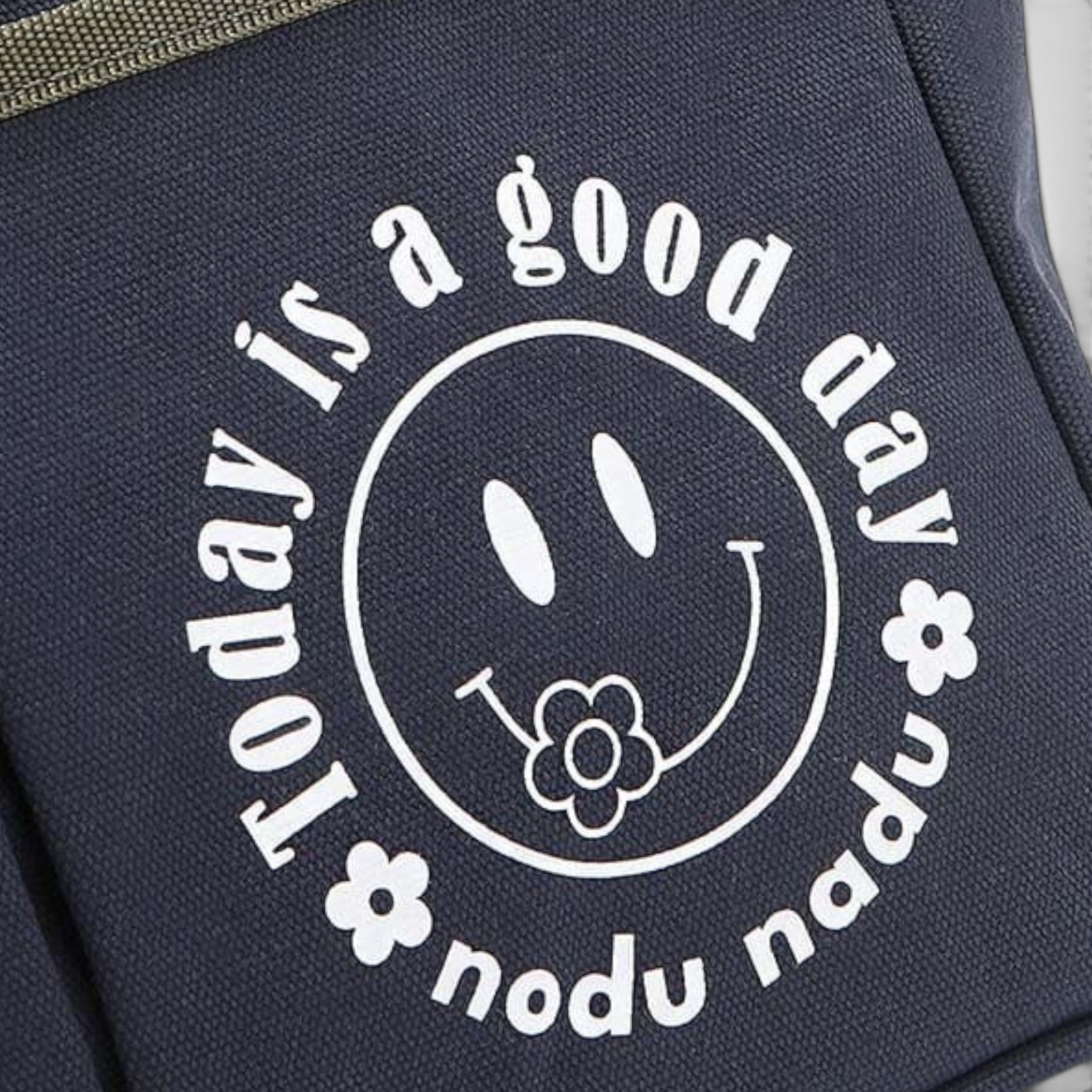 Navy blue bag with white text and smiley face design on a gray background