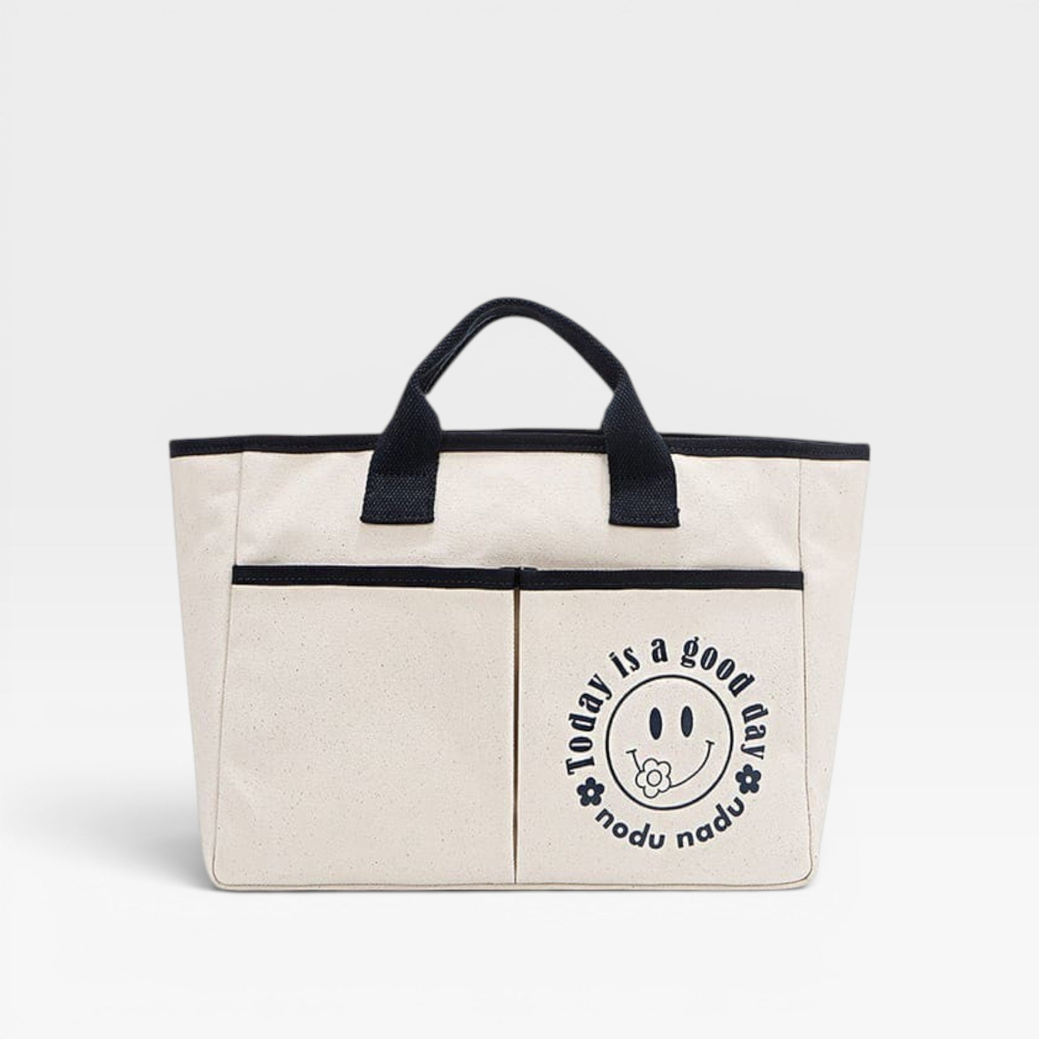 Beige tote bag with black handles and a smiley face design on a light gray background