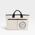 Beige tote bag with black handles and a smiley face design on a light gray background