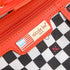 Red wallet with 'nicole lee' brand label on a checkered background