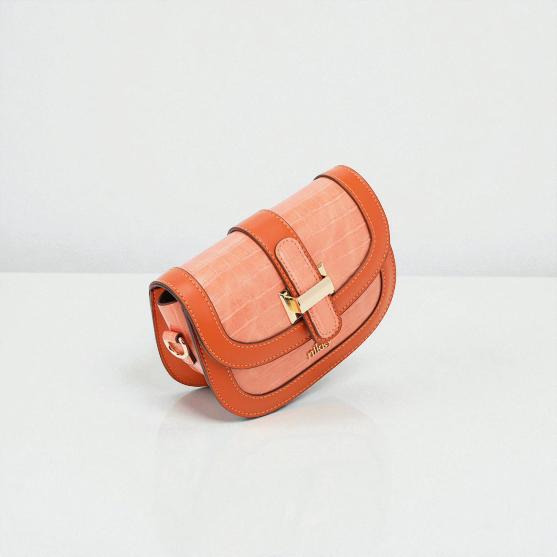 Orange handbag with gold buckle on a light gray background