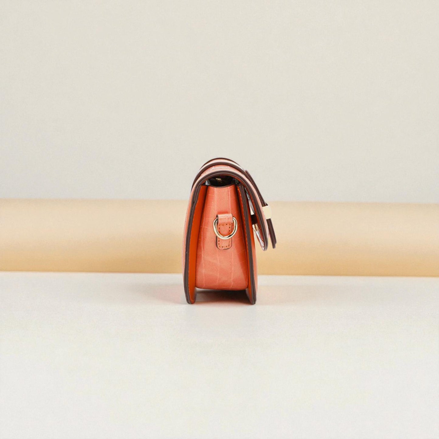 Brown leather handbag on a beige background
