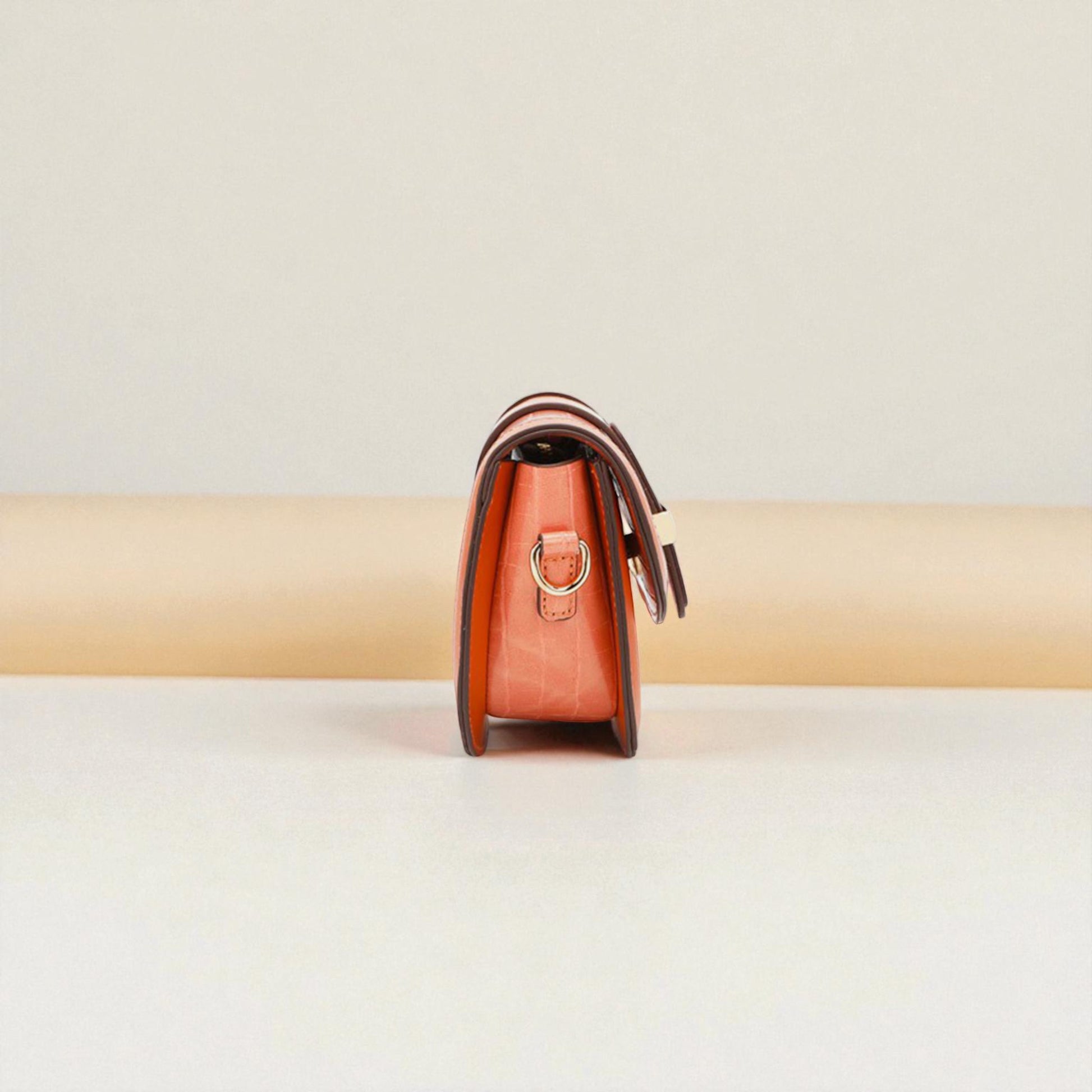 Brown leather handbag on a beige background