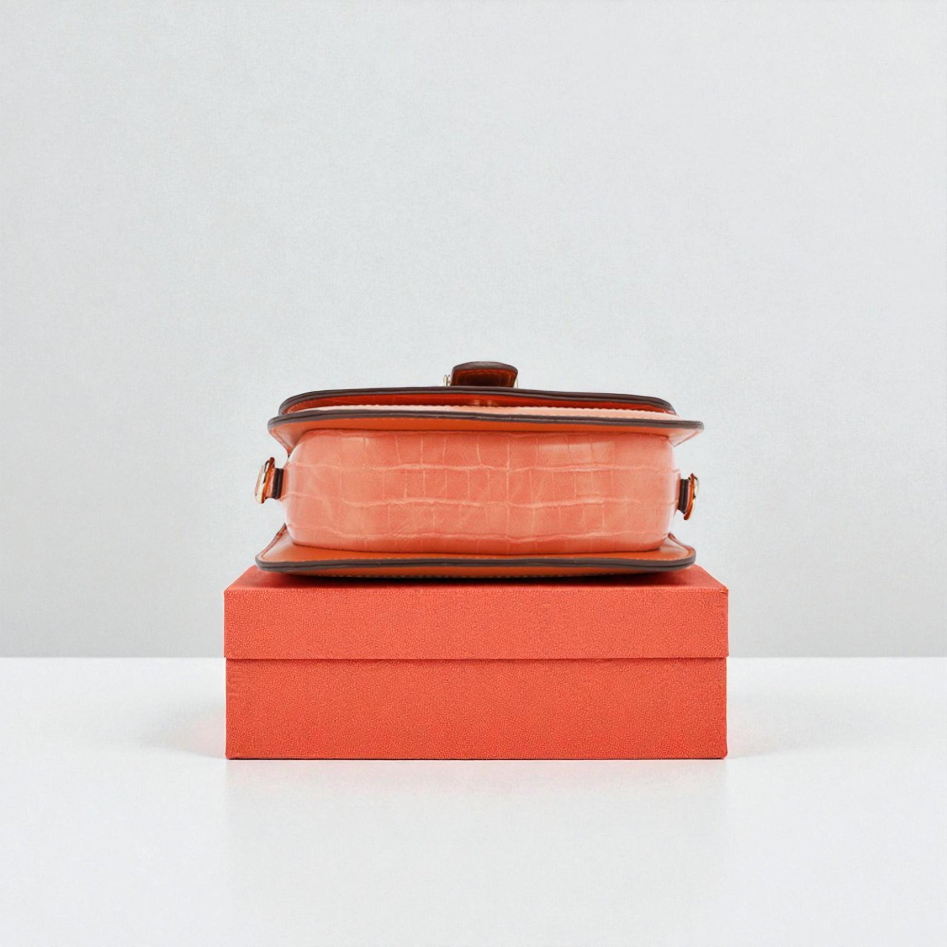 Ceramic dish with lid on an orange box against a white background