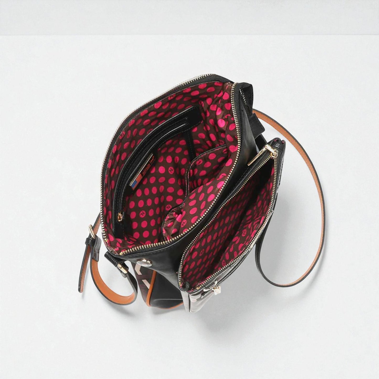 Black handbag with red polka dot interior on a white background