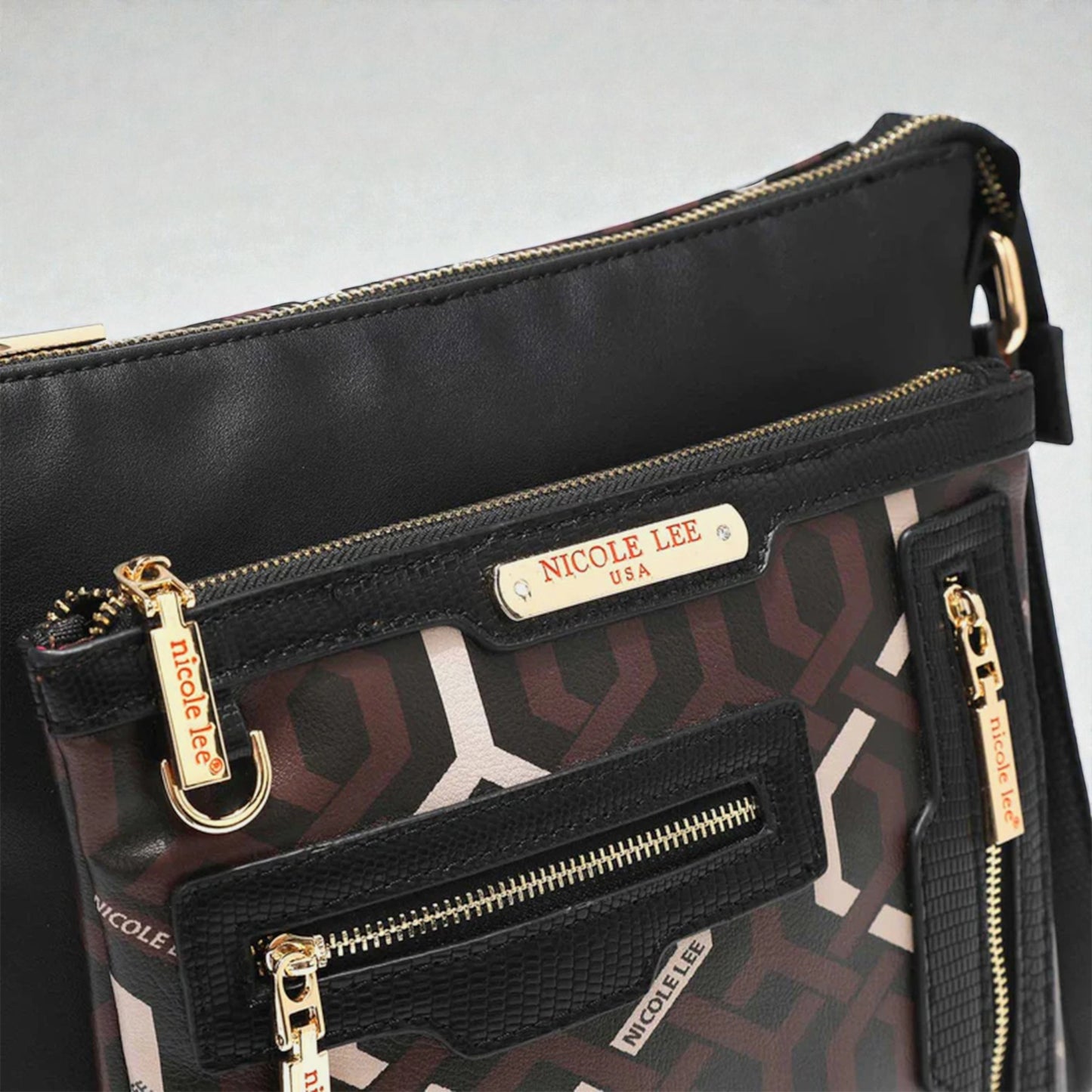 Black handbag with gold zippers and 'Nicole Lee' branding on a light gray background