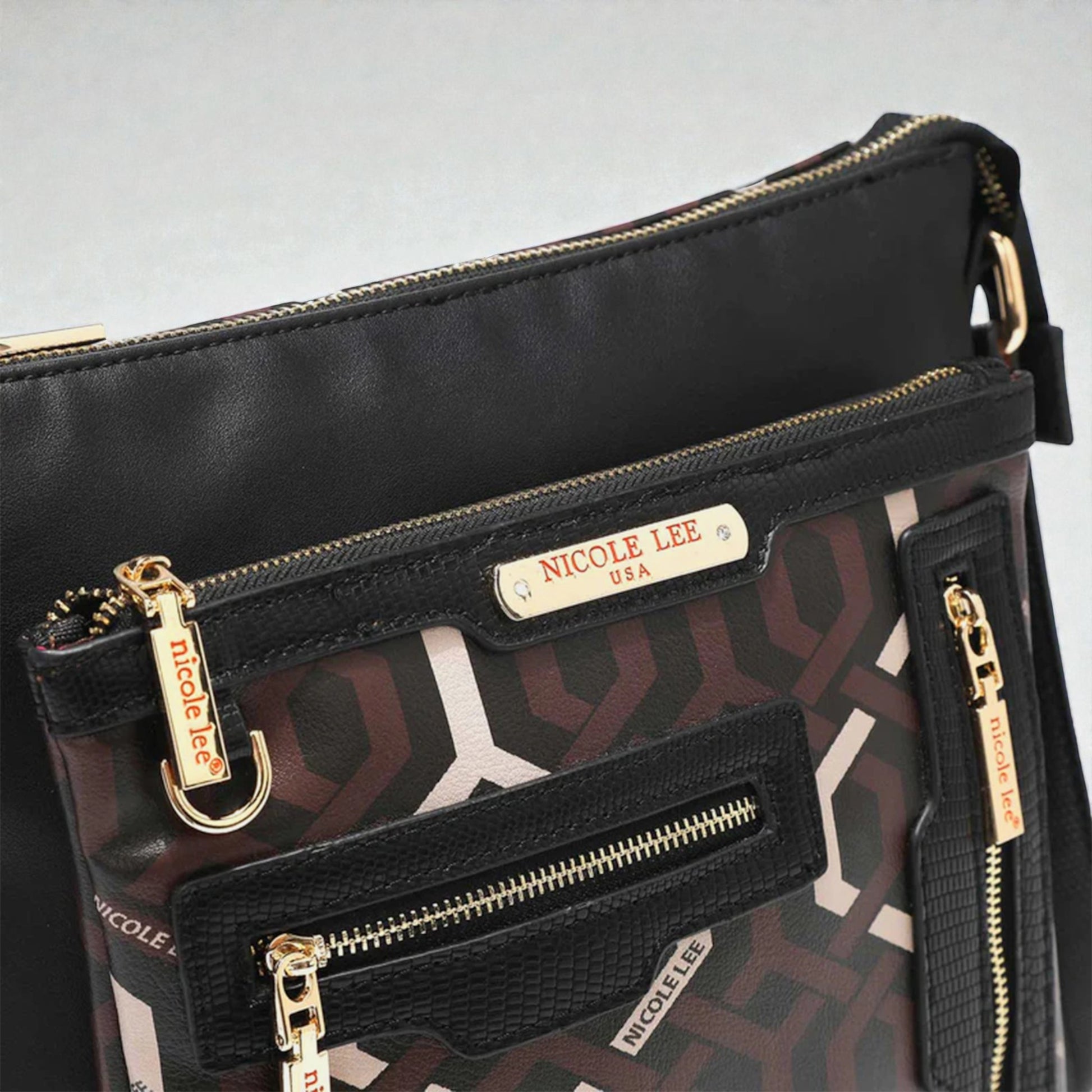 Black handbag with gold zippers and 'Nicole Lee' branding on a light gray background