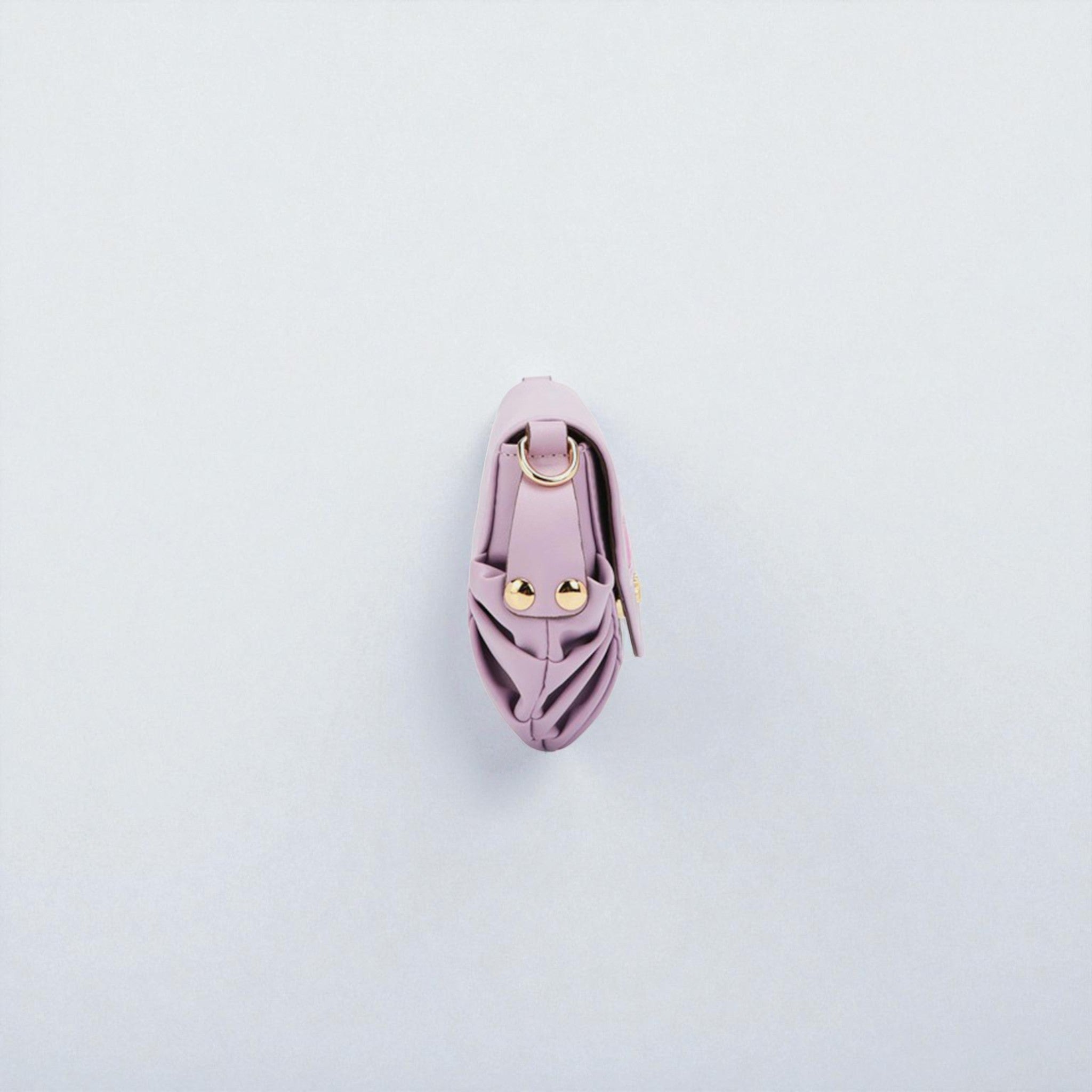Pink leather keychain with gold accents on a light gray background