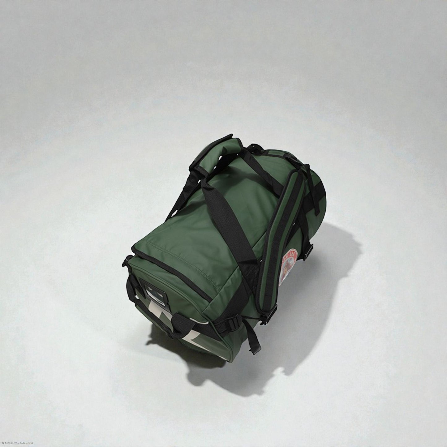 Green duffel bag with black straps on a white background