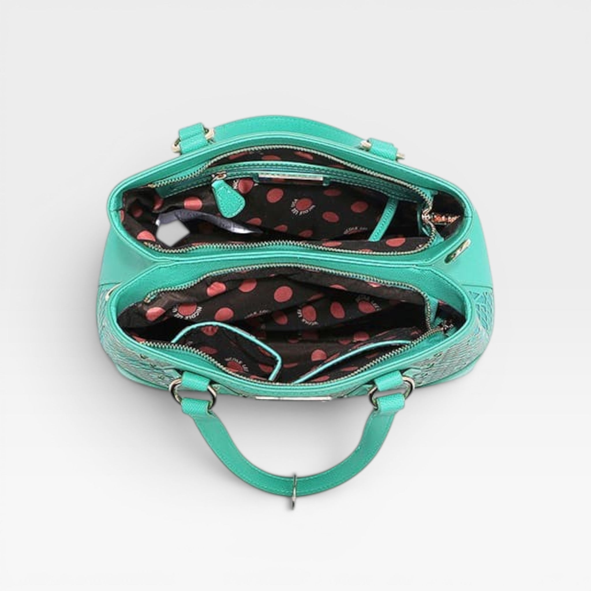 Turquoise handbag with black and red polka dot interior on a white background