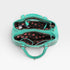 Turquoise handbag with black and red polka dot interior on a white background
