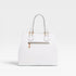 White handbag with gold accents on a light gray background