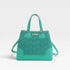 Turquoise handbag with a subtle pattern on a light gray background