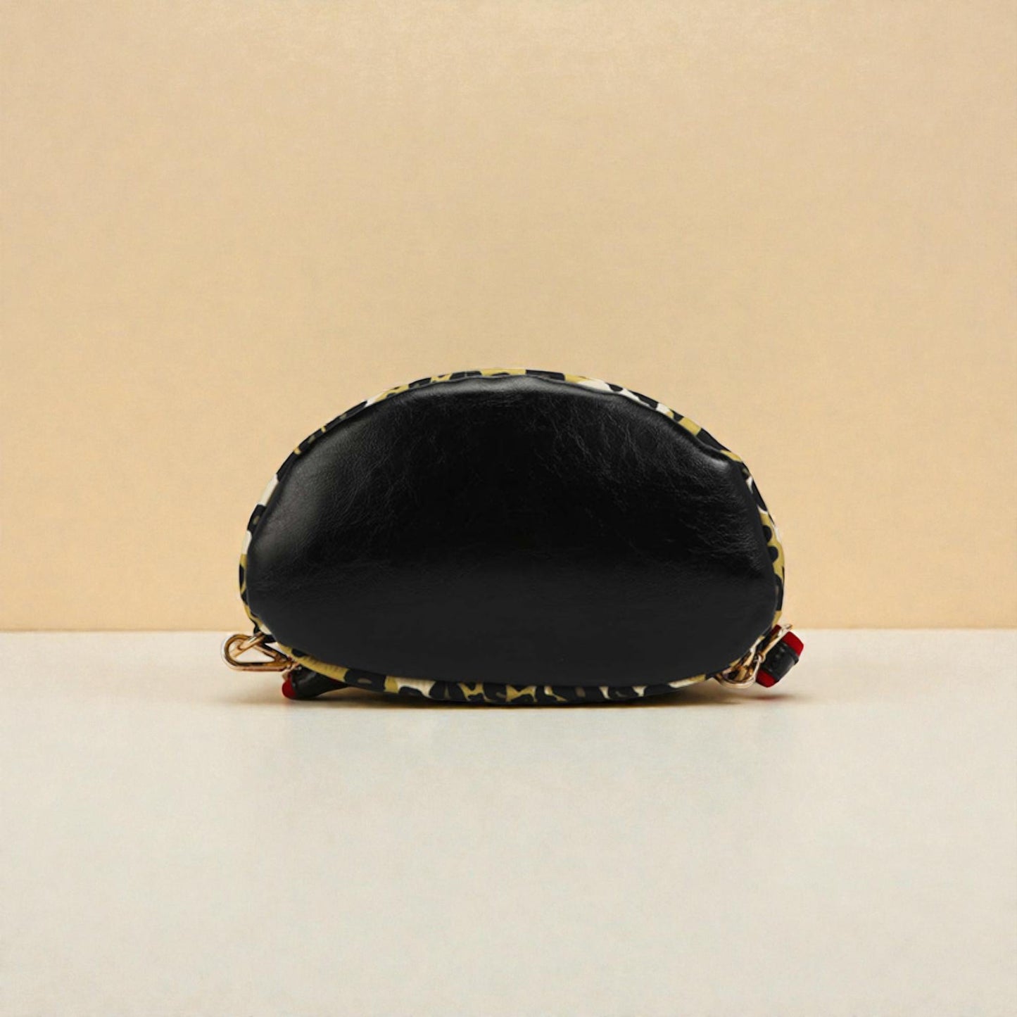 Black cosmetic bag with floral patterns on a beige background