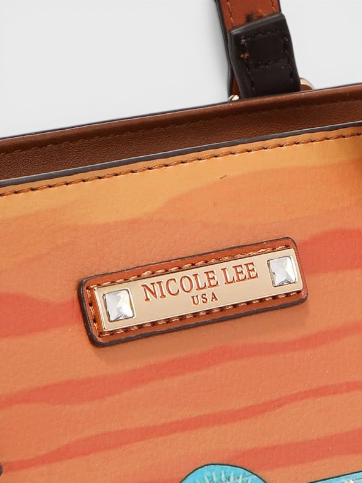 Close-up of an orange handbag with 'Nicole Lee' branding on a white background