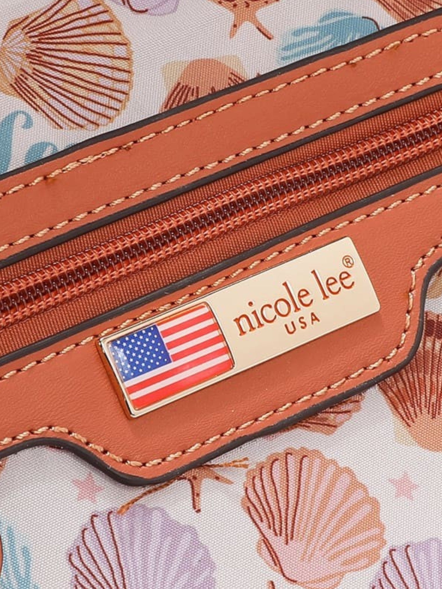 Close-up of a Nicole Lee product with an American flag emblem on a patterned background.