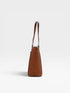 Brown handbag with a textured pattern on a light gray background