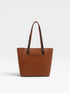 Brown leather tote bag on a light gray background