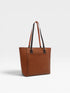 Brown woven handbag with black accents on a light gray background