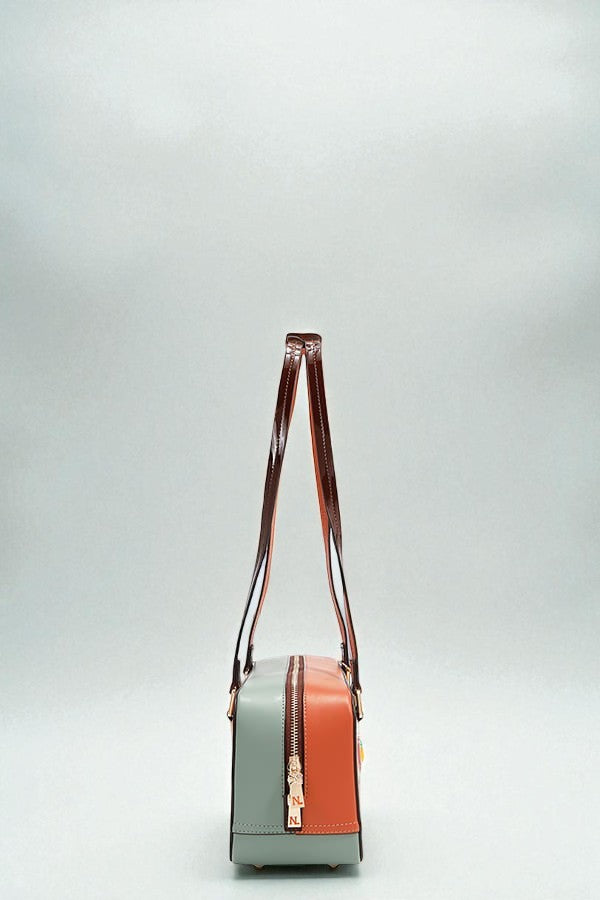 Two-tone handbag with a gradient design on a light gray background