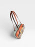 Multicolored handbag with a floral pattern on a light gray background