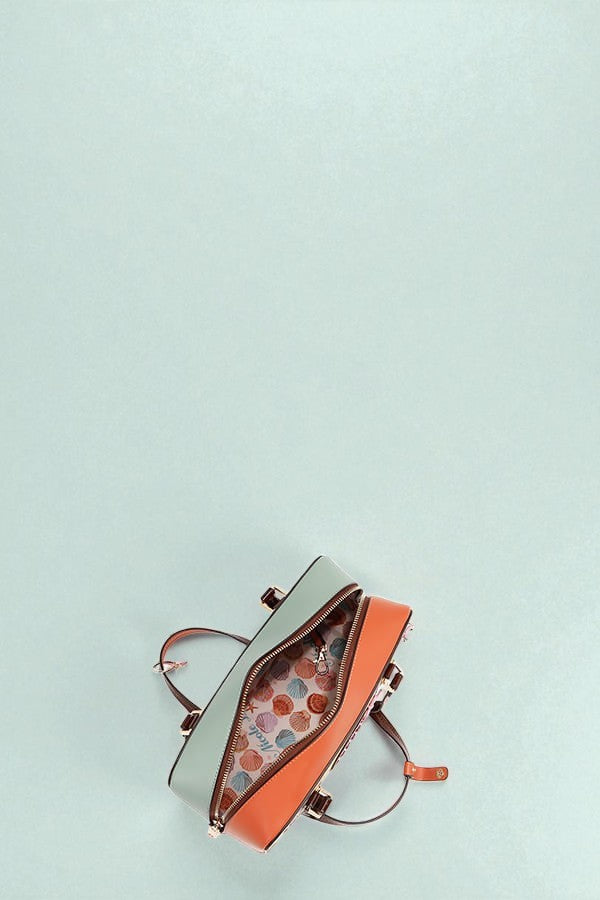 Handbag with orange interior on a light blue background