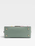 Green handbag with gold accents on a light gray background