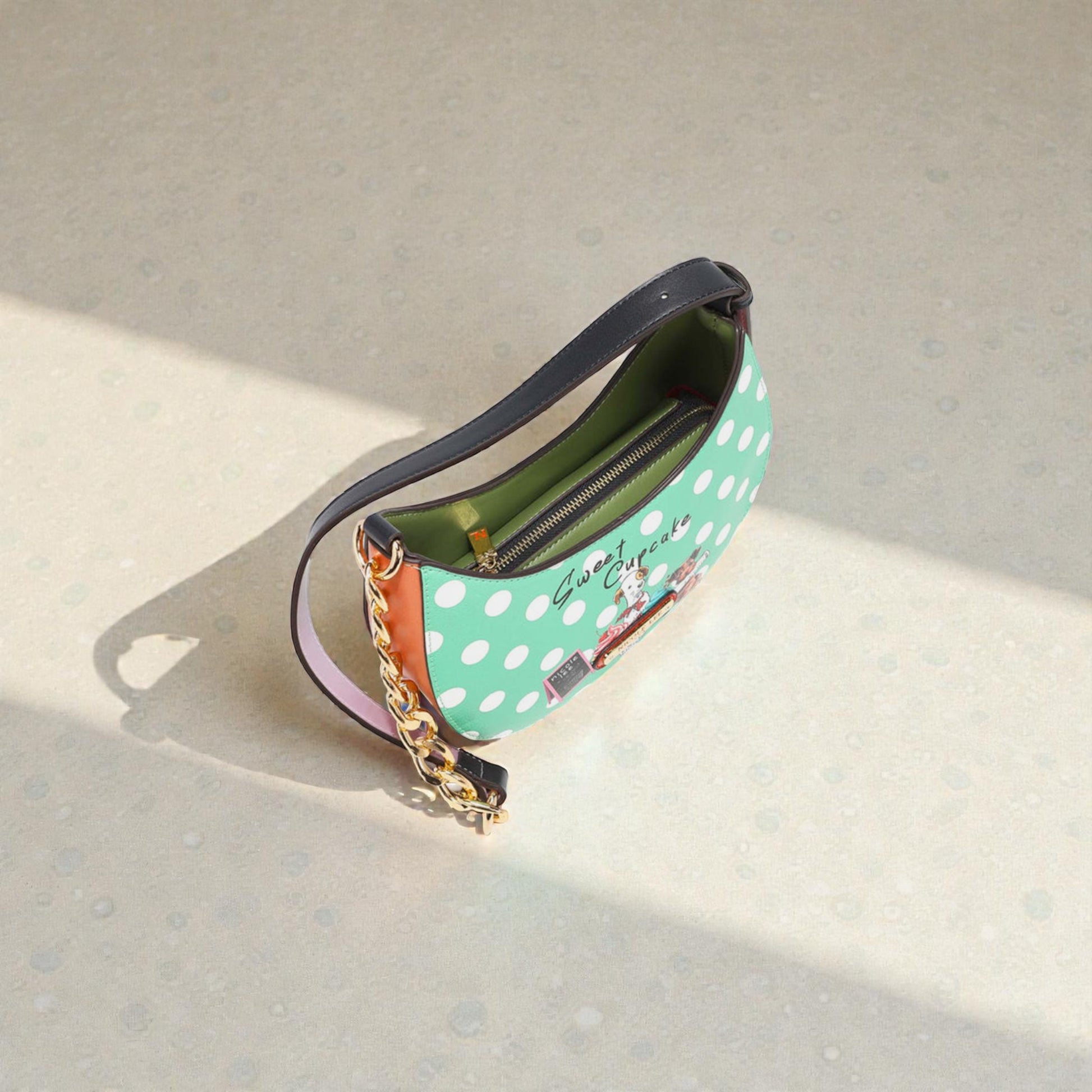 Polka dot handbag with a chain detail on a light background