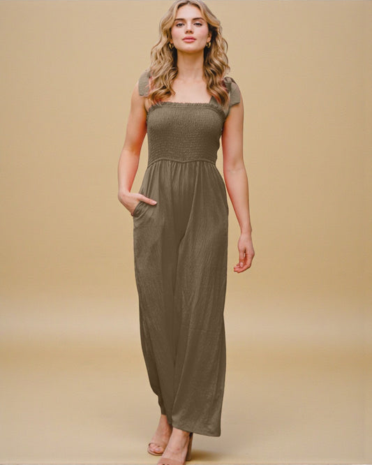 Woman wearing a long olive green dress against a beige background