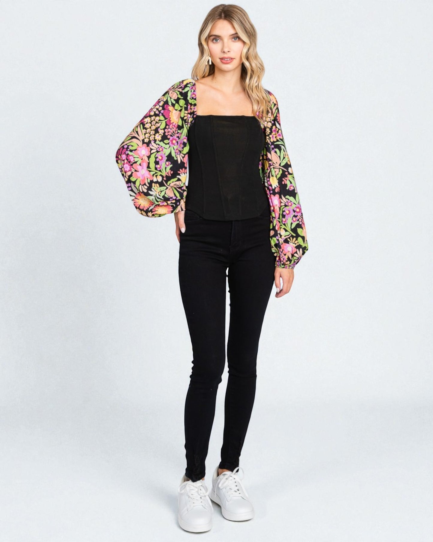 Woman wearing a floral kimono over a black outfit on a white background