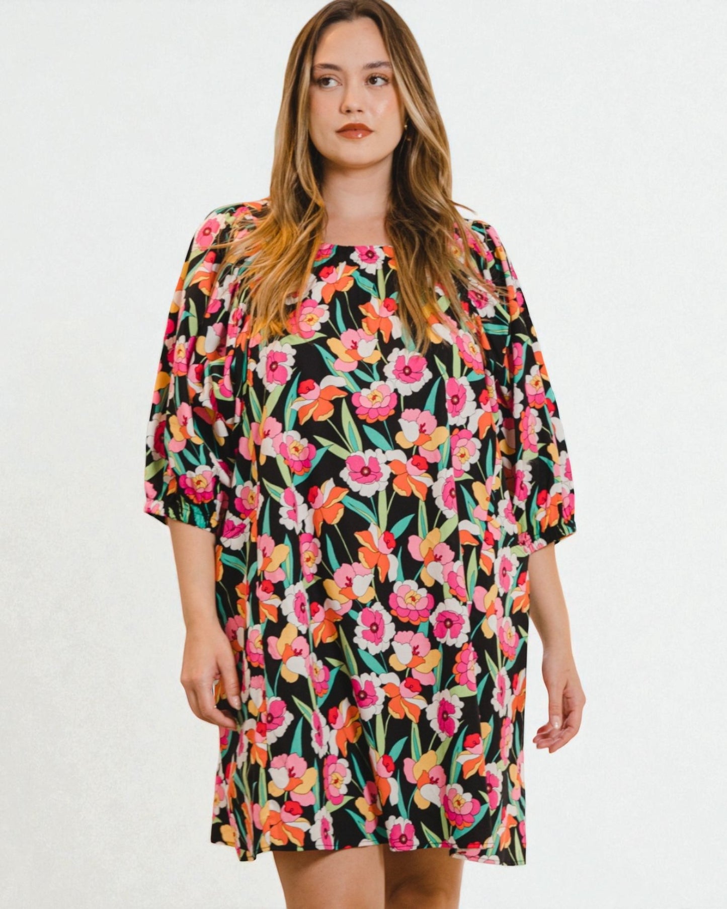 Woman wearing a colorful floral dress on a white background