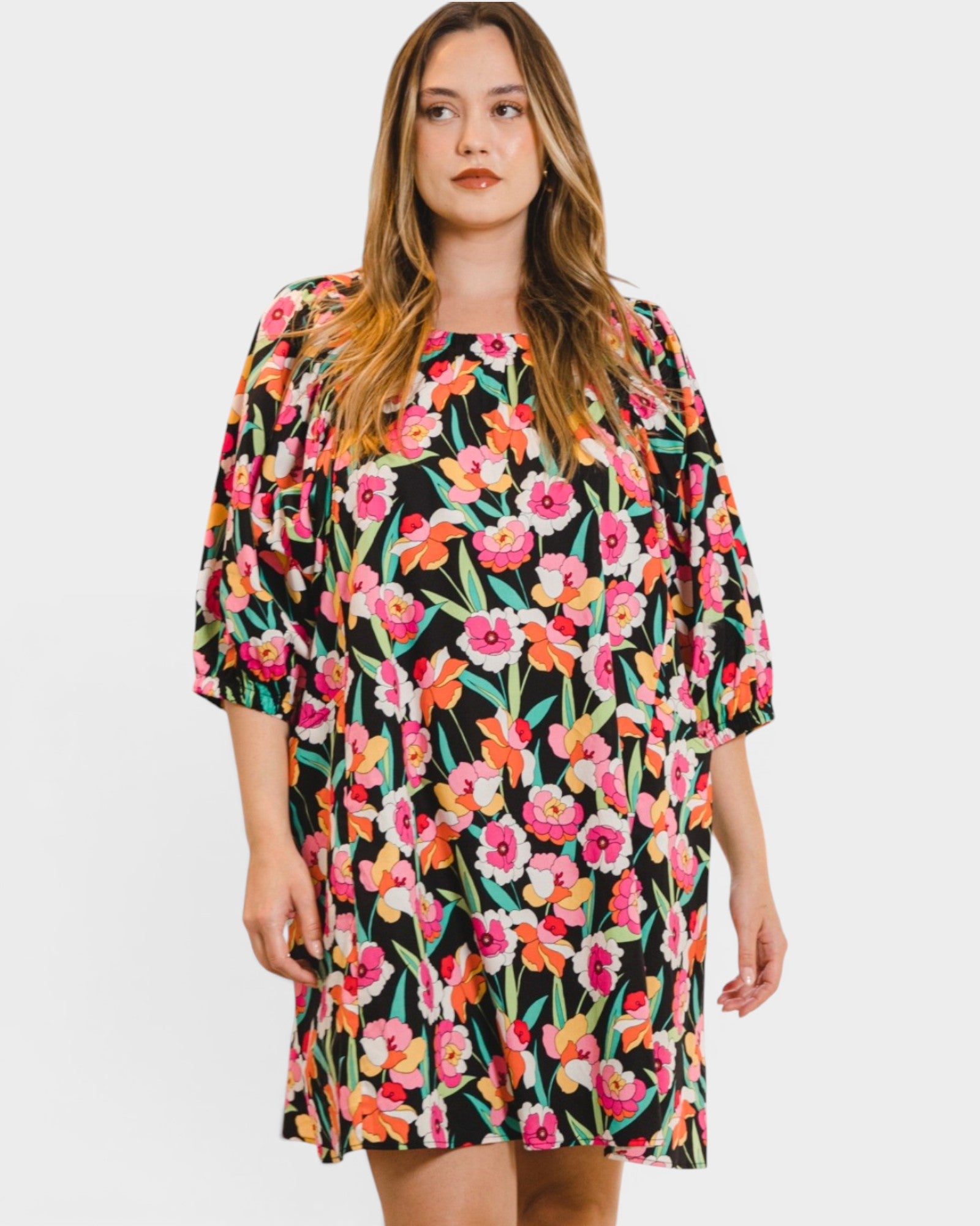 Woman wearing a colorful floral dress on a white background