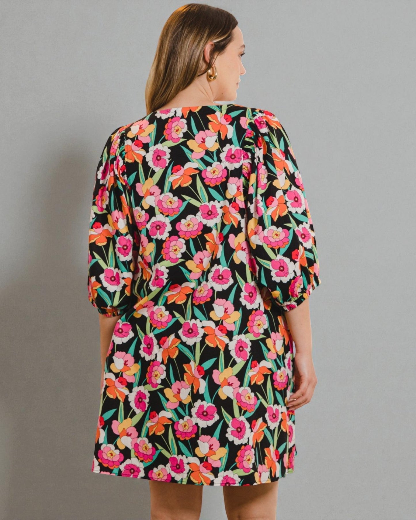 Woman wearing a floral dress with a plain background