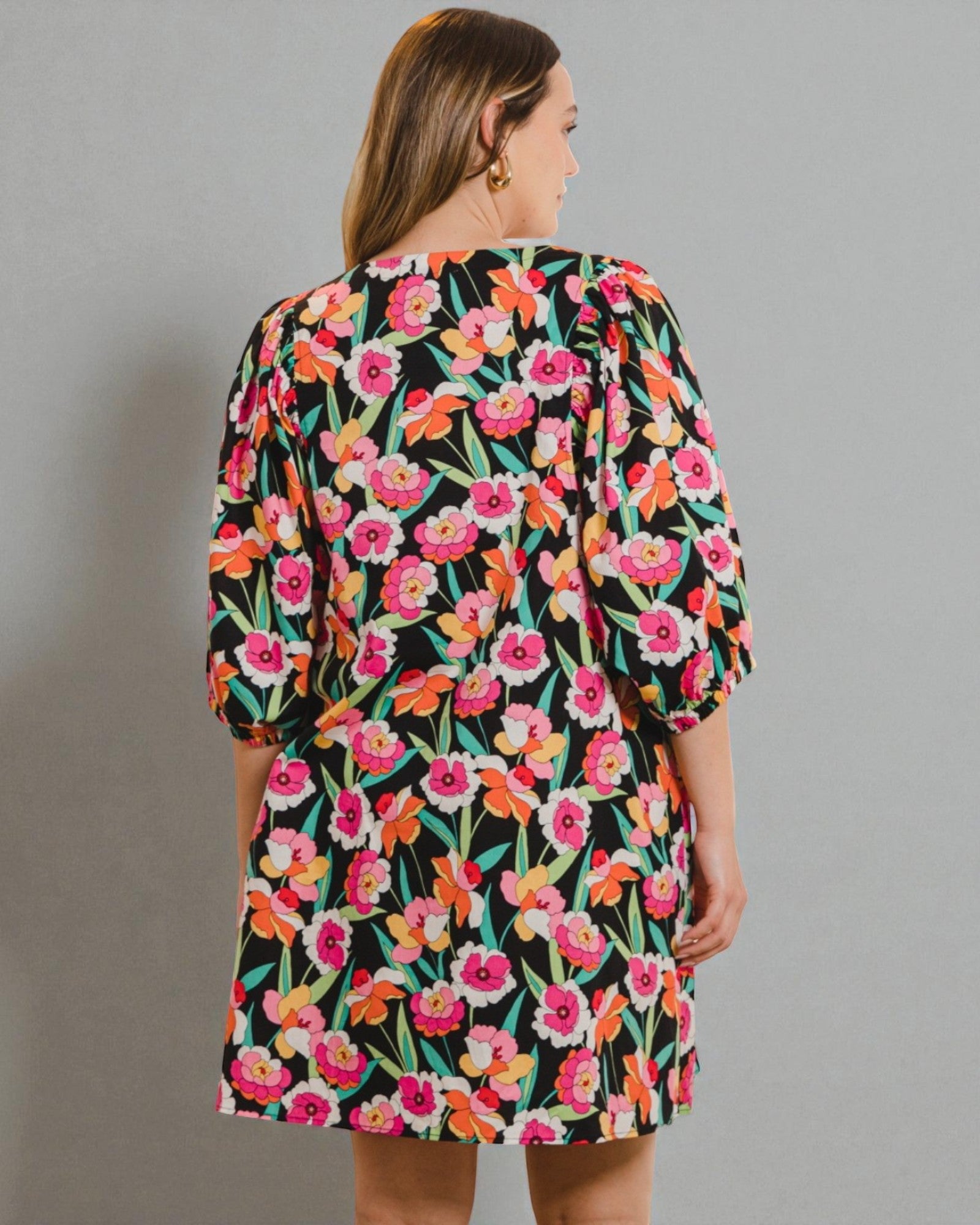 Woman wearing a floral dress with a plain background