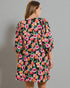 Woman wearing a floral dress with a plain background