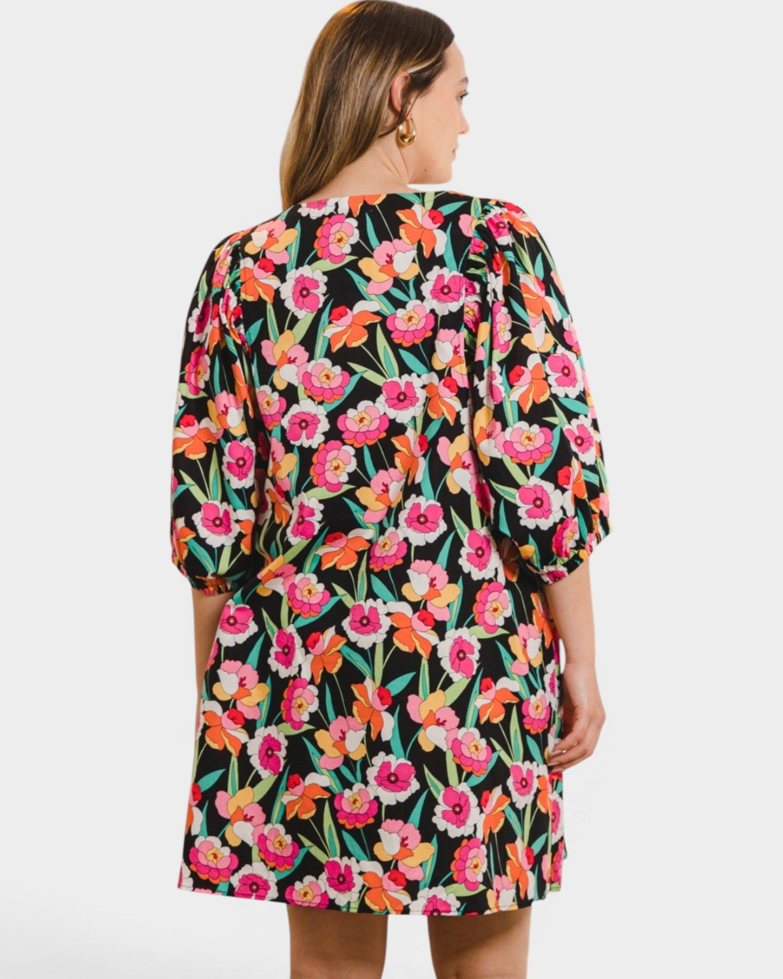 Woman wearing a colorful floral dress on a white background