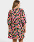 Woman wearing a colorful floral dress on a white background