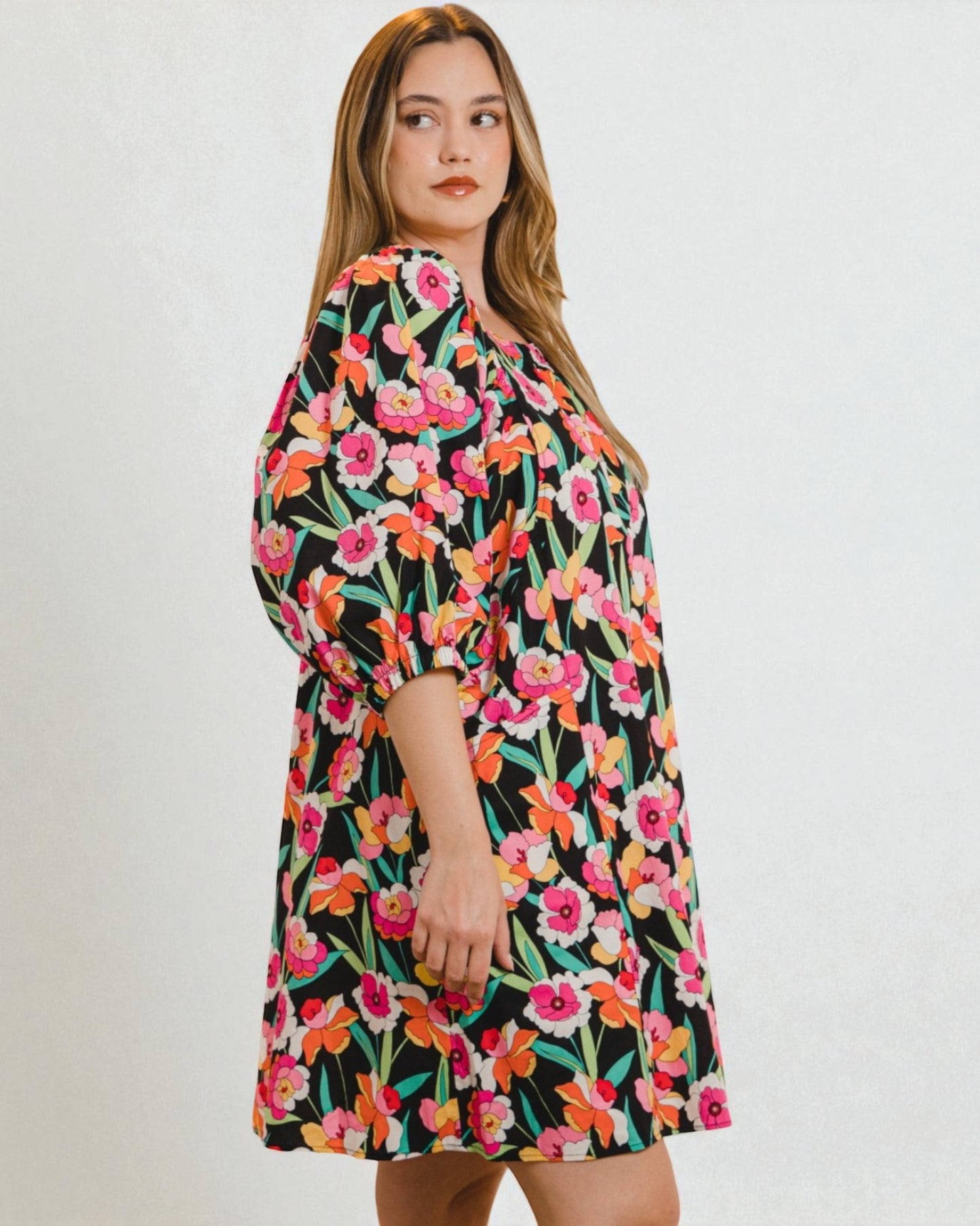Woman wearing a floral dress on a plain background