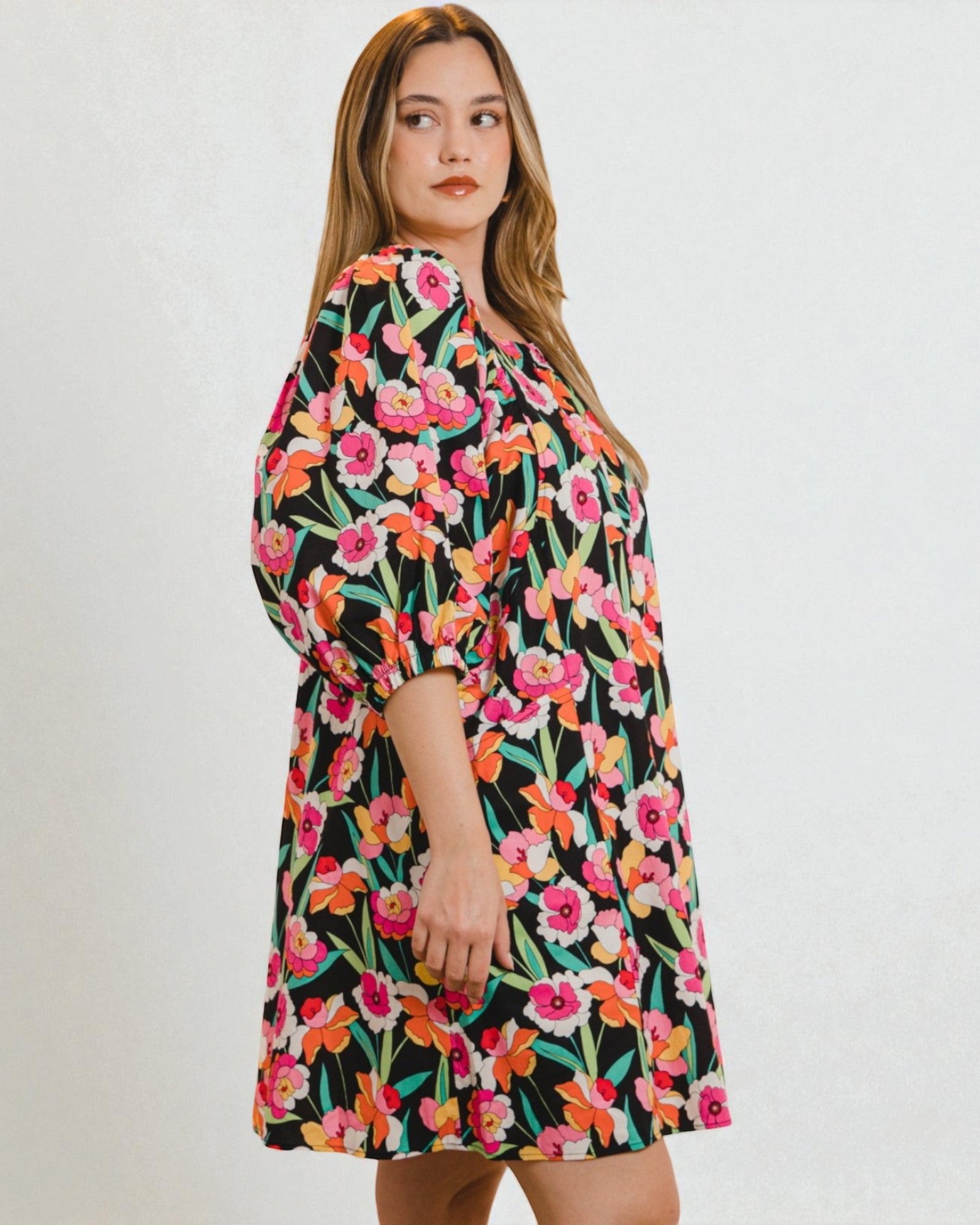 Woman wearing a floral dress on a plain background