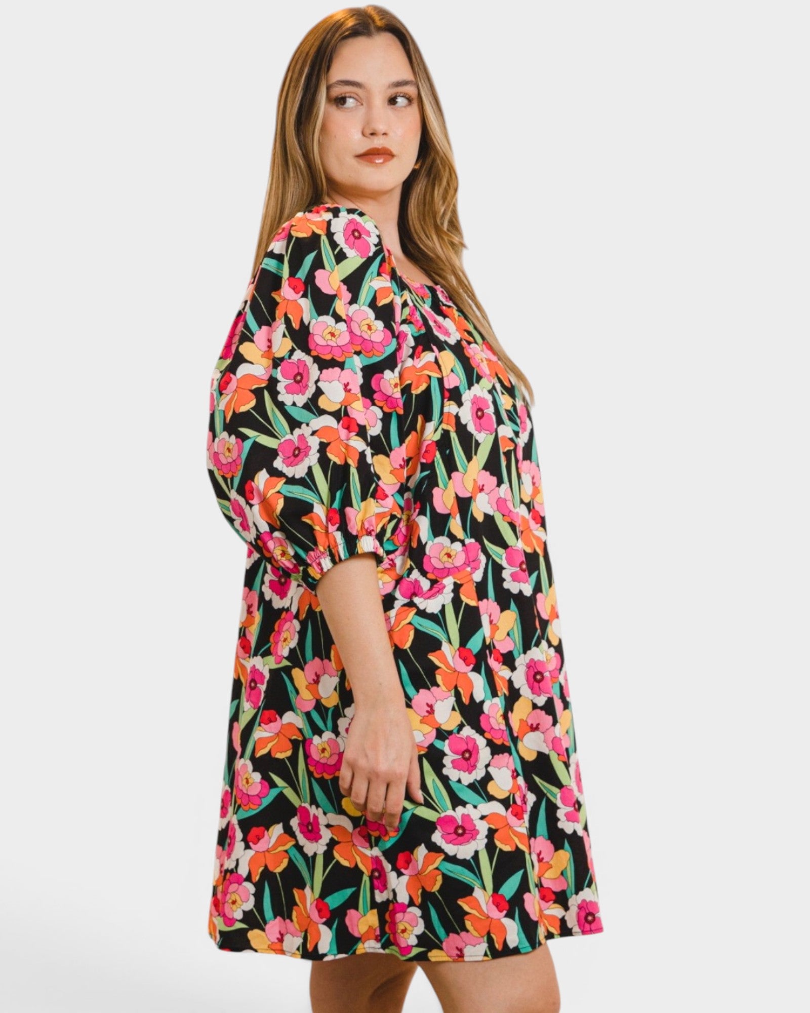 Woman wearing a colorful floral dress on a white background