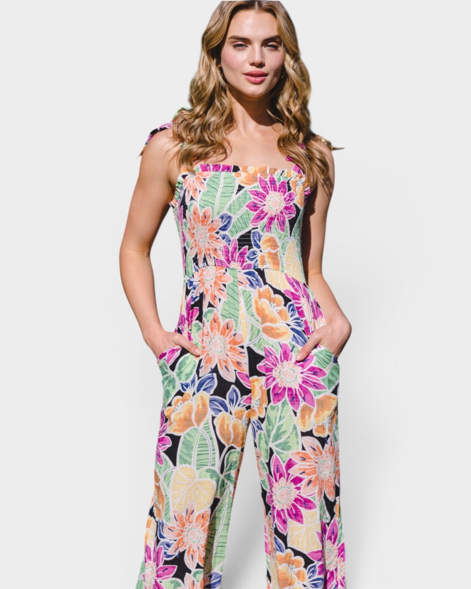 Woman wearing a colorful floral jumpsuit on a white background