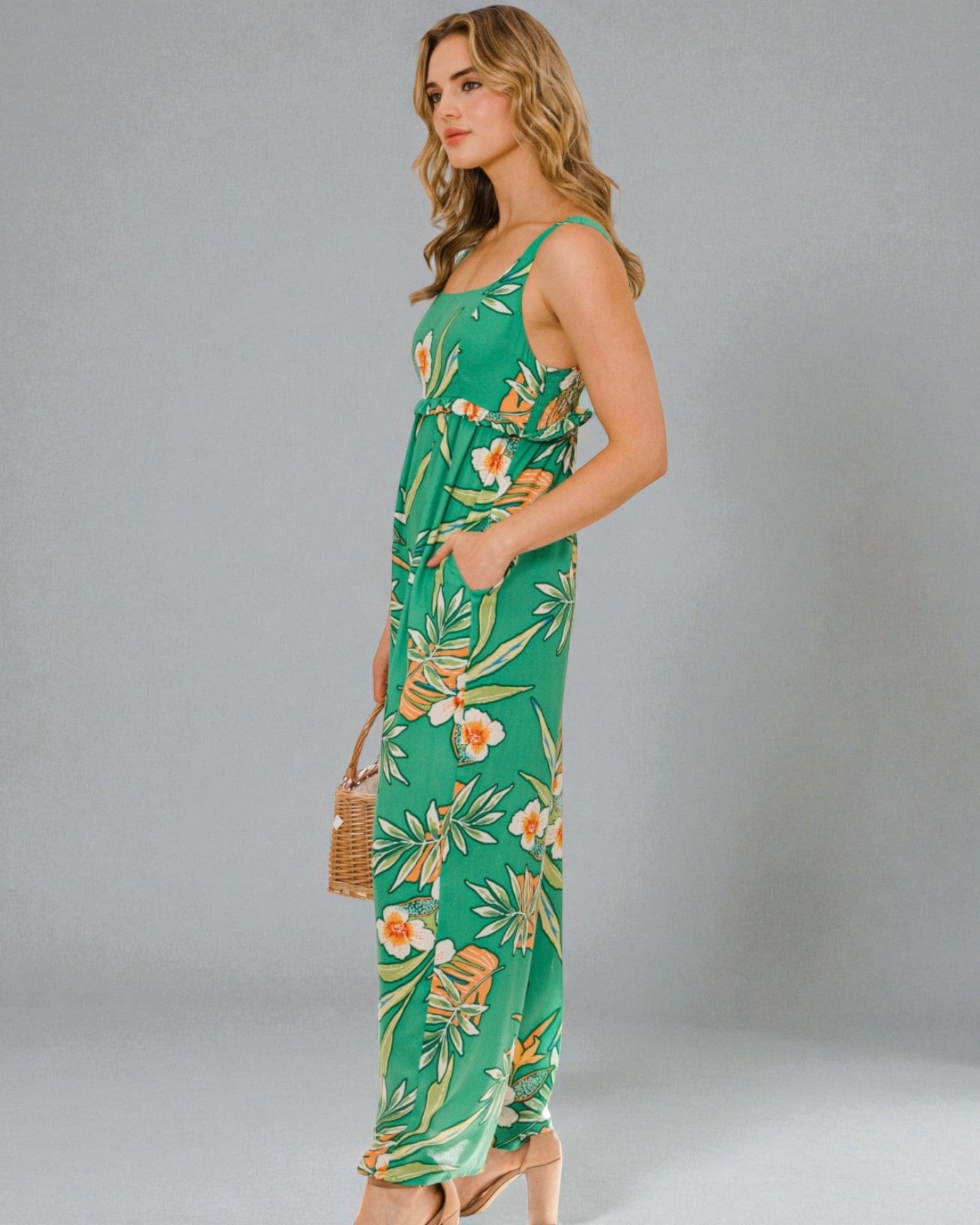 Woman wearing a green floral dress against a gray background