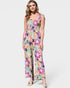 Woman wearing a colorful floral jumpsuit on a white background