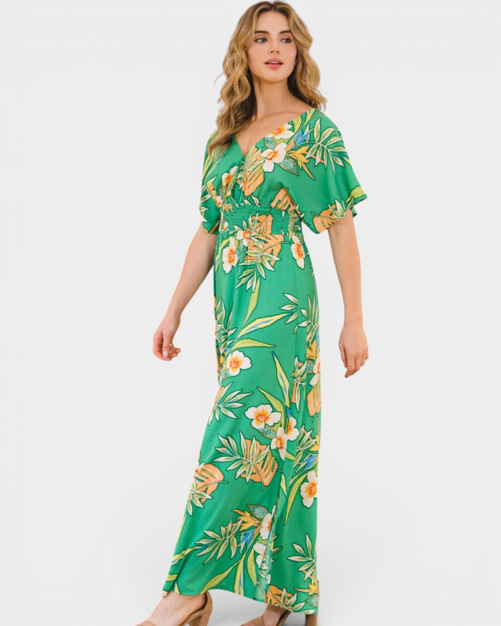 Woman wearing a green floral dress on a white background
