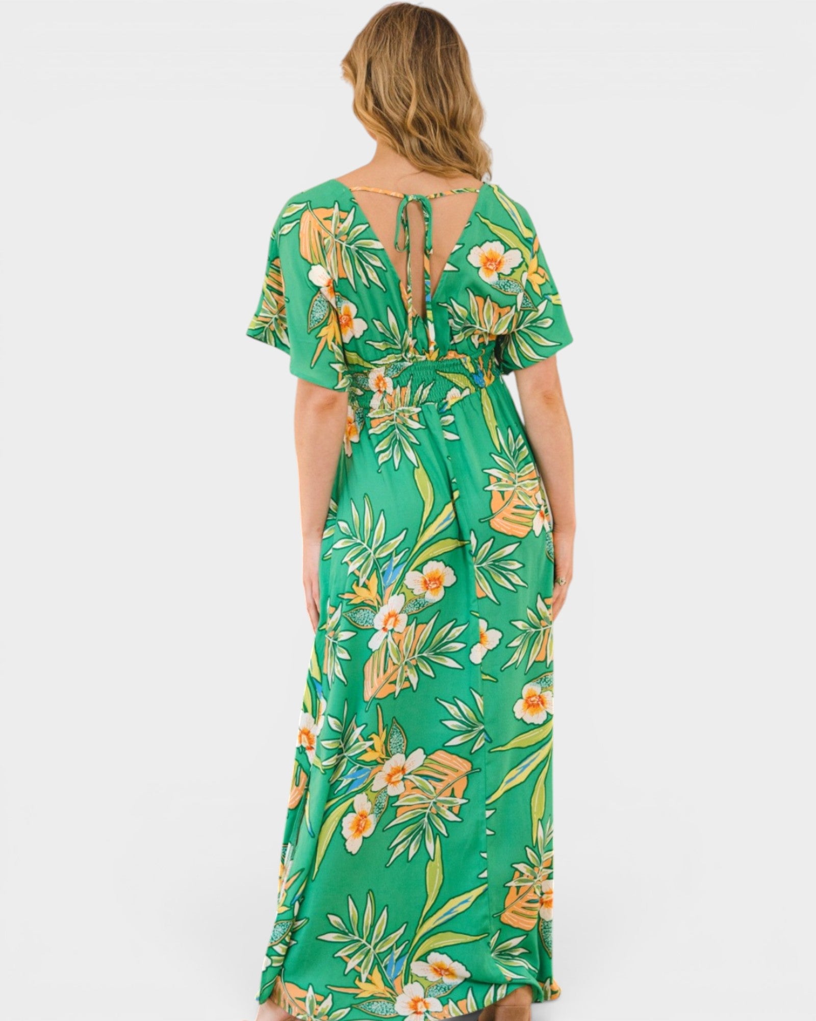 Woman wearing a green floral dress on a white background