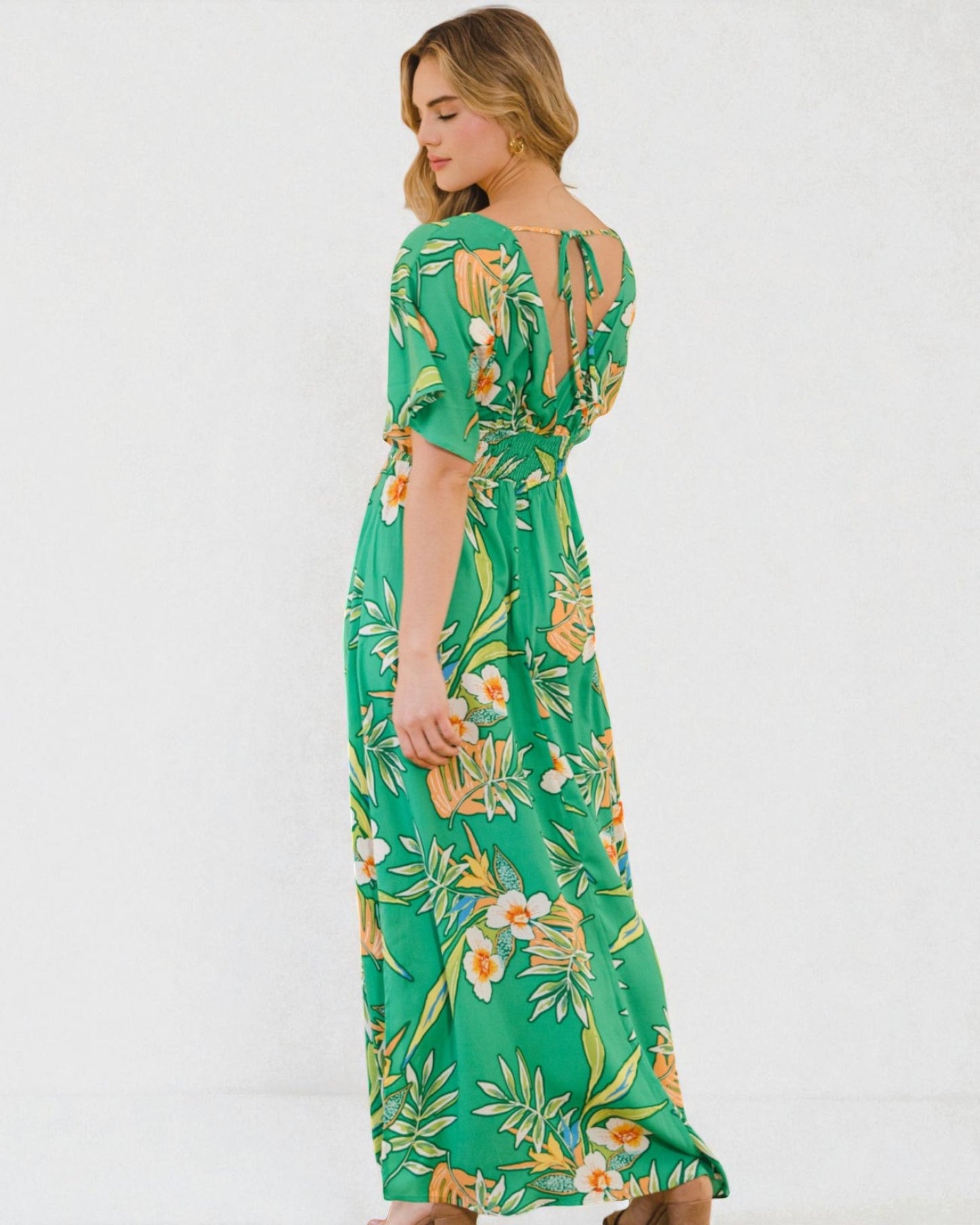 Woman wearing a green floral dress on a white background