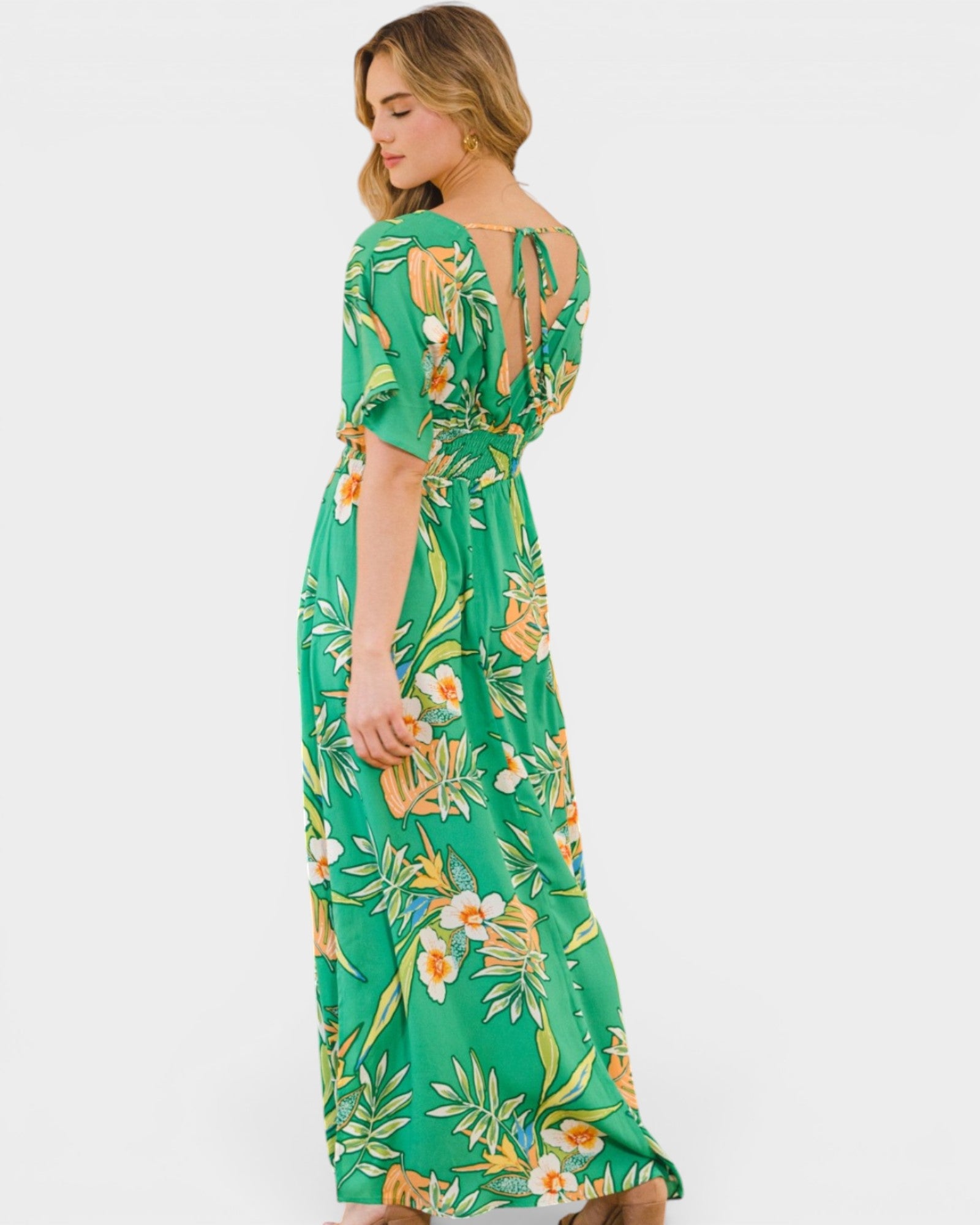 Woman wearing a green floral dress on a white background